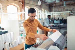 bearded man printing posters for social campaign