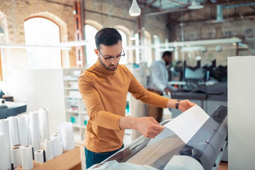 bearded man printing posters for social campaign