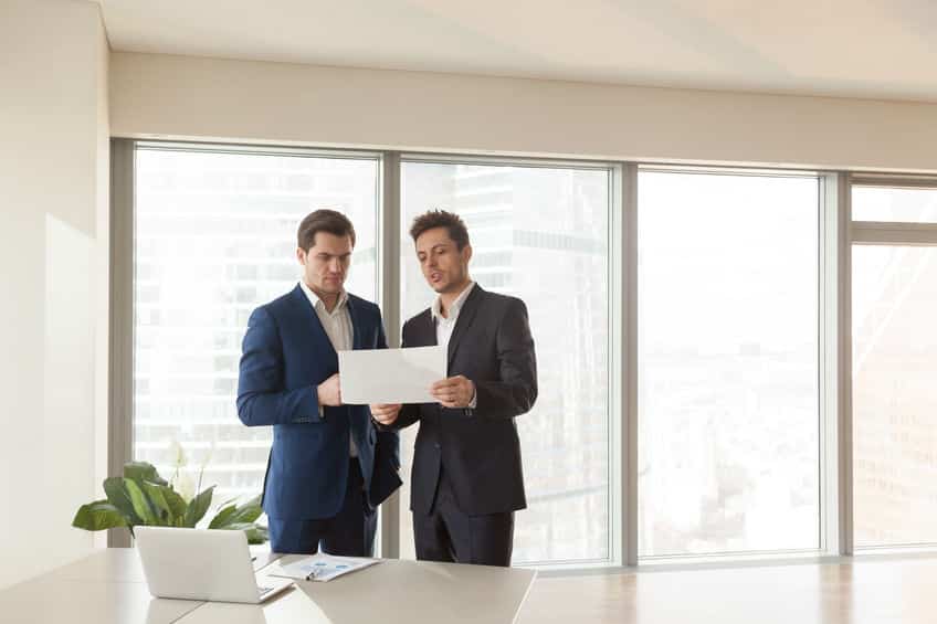 two serious businessmen discussing building plan, construction i